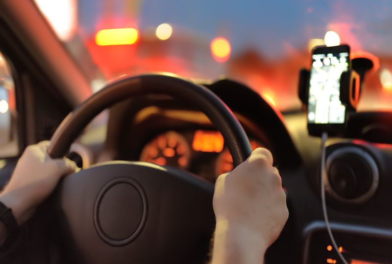 Male driver ride a car during evening traffic jam. Drive in the night city.