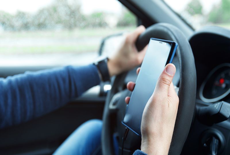 Male hands with phone. Man in car is using smartphone.